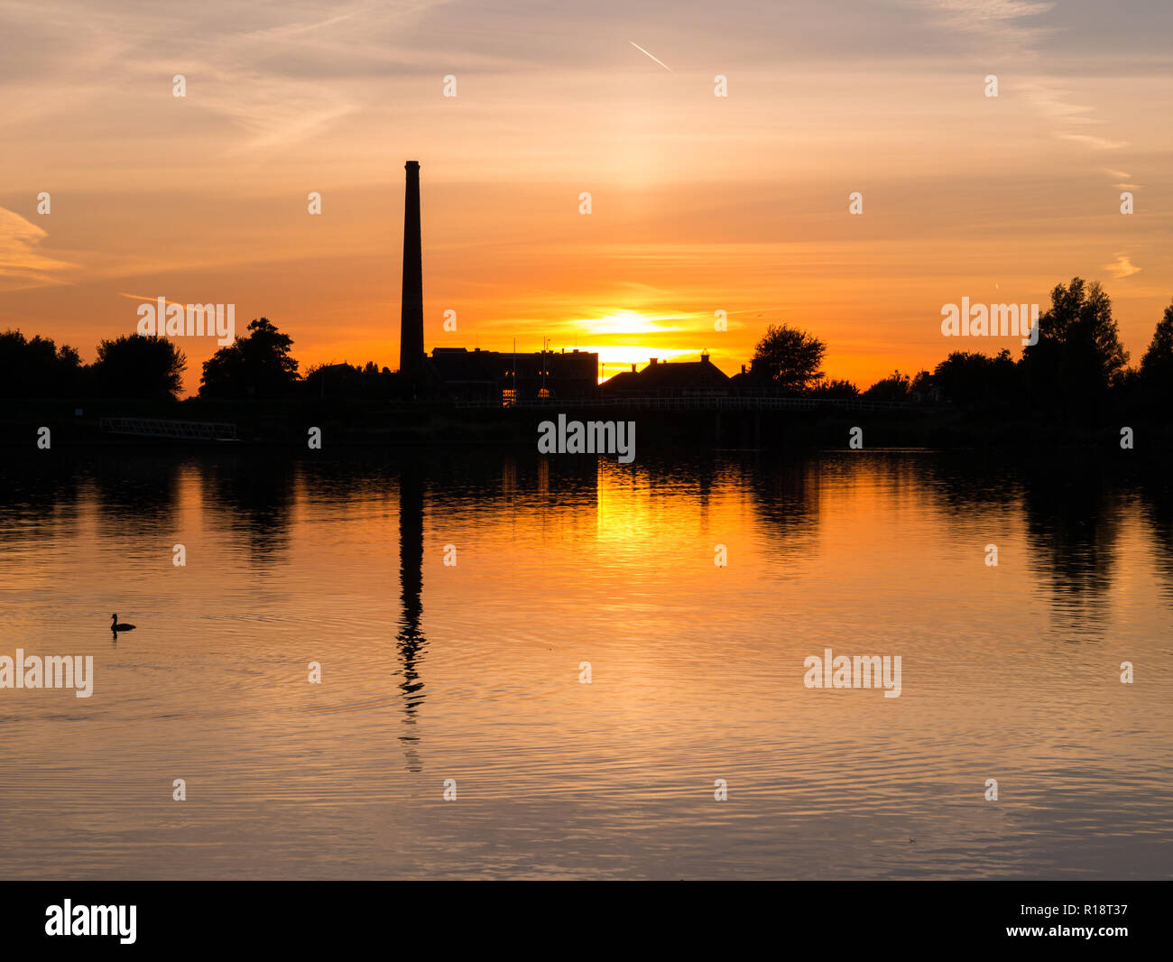 Waterfront silhouette of steam pumping station with museum at sunset, Medemblik, Noord-Holland, Netherlands Stock Photo