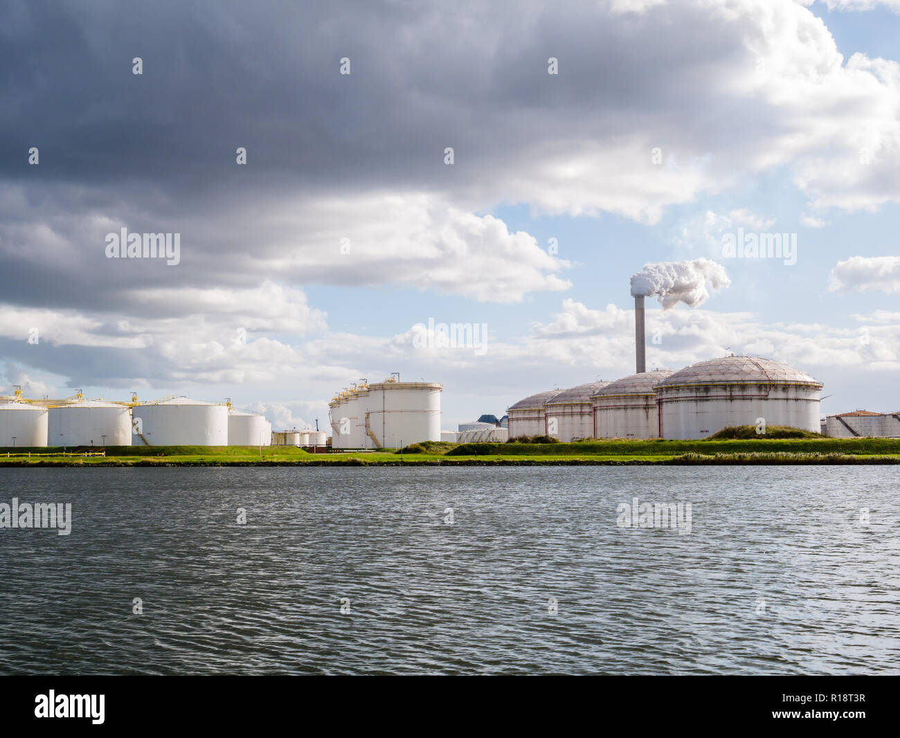 Oil storage tanks and exhaust stack of power station Hemweg in Westpoort, Port of Amsterdam, North Sea Canal, Netherlands Stock Photo
