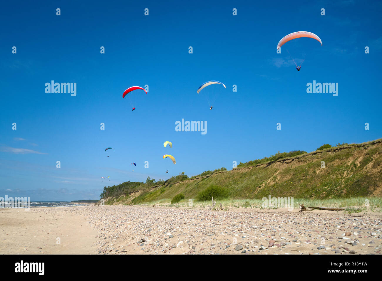 Paragliding in dynamic wind along the dunes in the beach Stock Photo