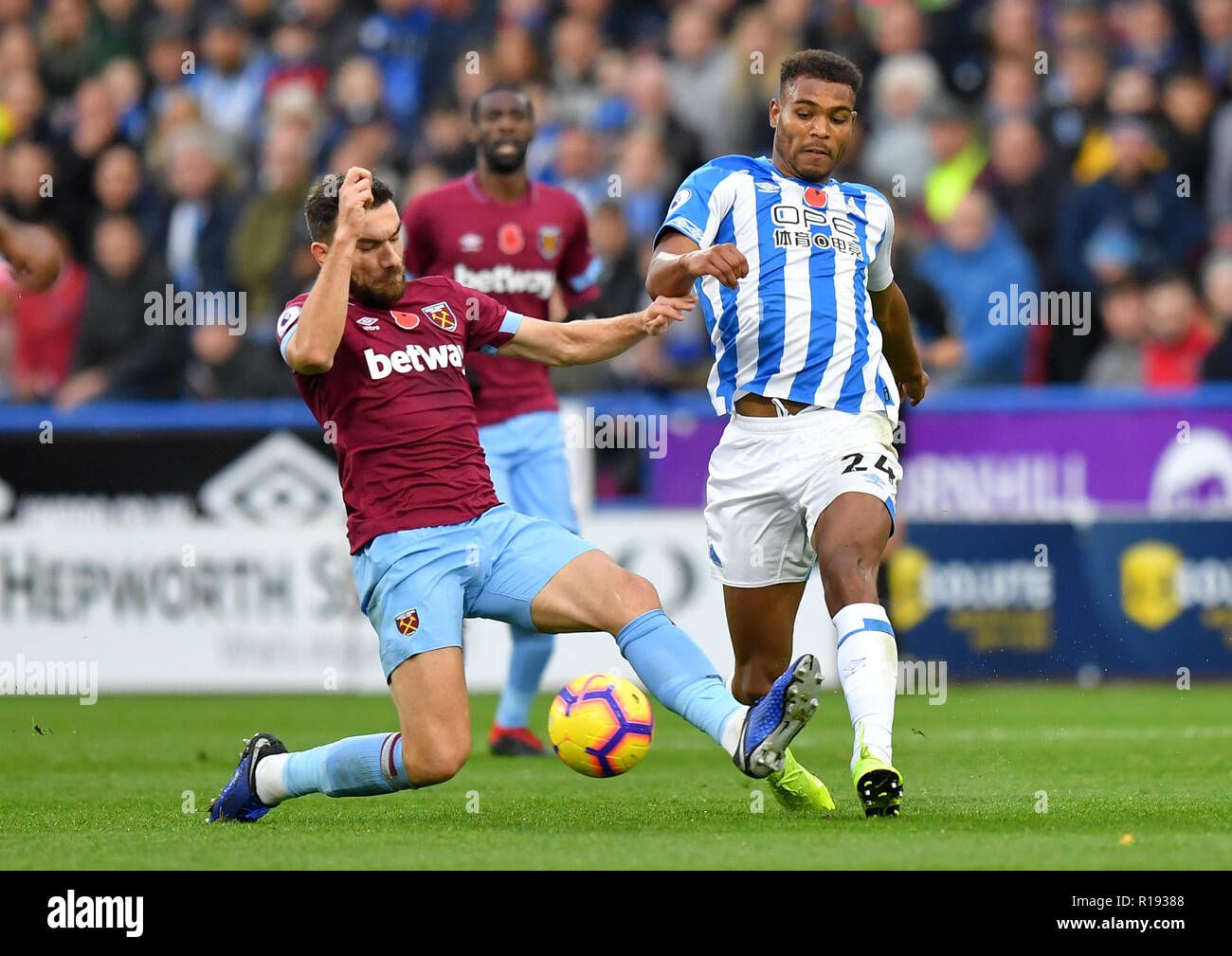 West Ham United's Robert Snodgrass (left) and Huddersfield Town's Steve Mounie battle for the ball during the Premier League match at the John Smith's Stadium, Huddersfield. Stock Photo