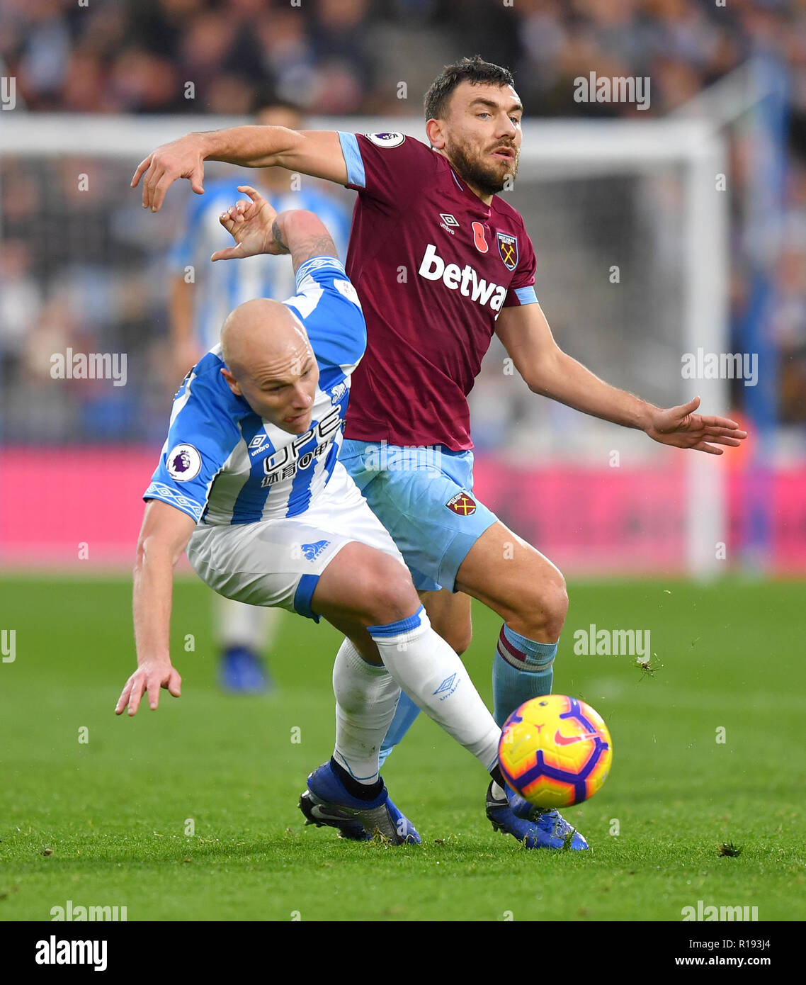 Huddersfield Town's Aaron Mooy (left) and West Ham United's Robert Snodgrass battle for the ball during the Premier League match at the John Smith's Stadium, Huddersfield. Stock Photo