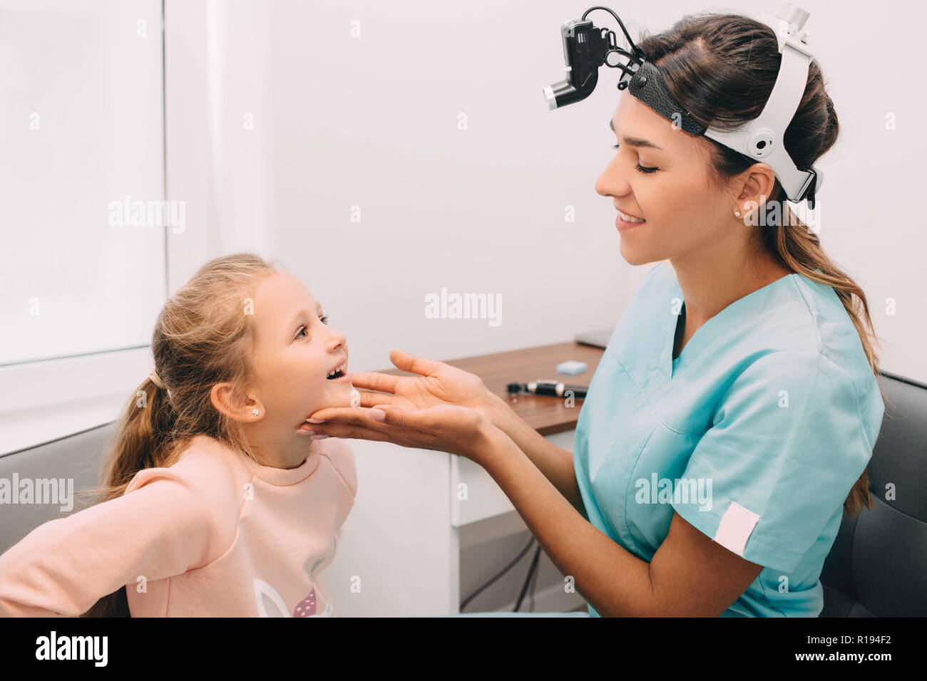 ENT doctor examining mouth of little girl at clinic Stock Photo