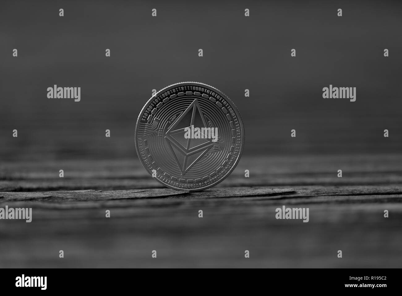 Ethereum Classic cryptocurrency physical coin placed on wooden decking floor Stock Photo