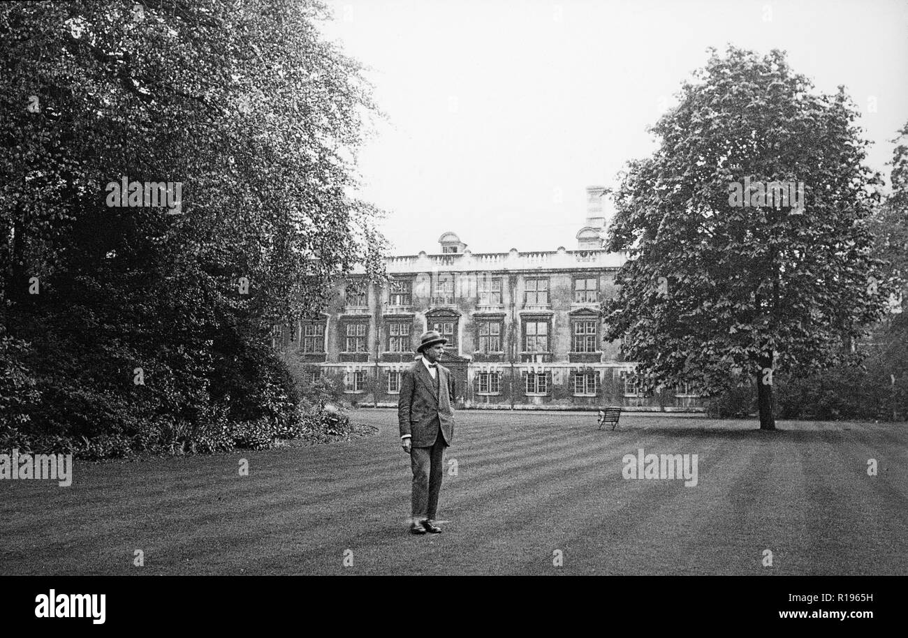 A vintage black and white photograph, taken in May 1924, showing  a man standing in a garden with the Fellow's Building, part of Christ's College, Cambridge University, England, in the background. Stock Photo