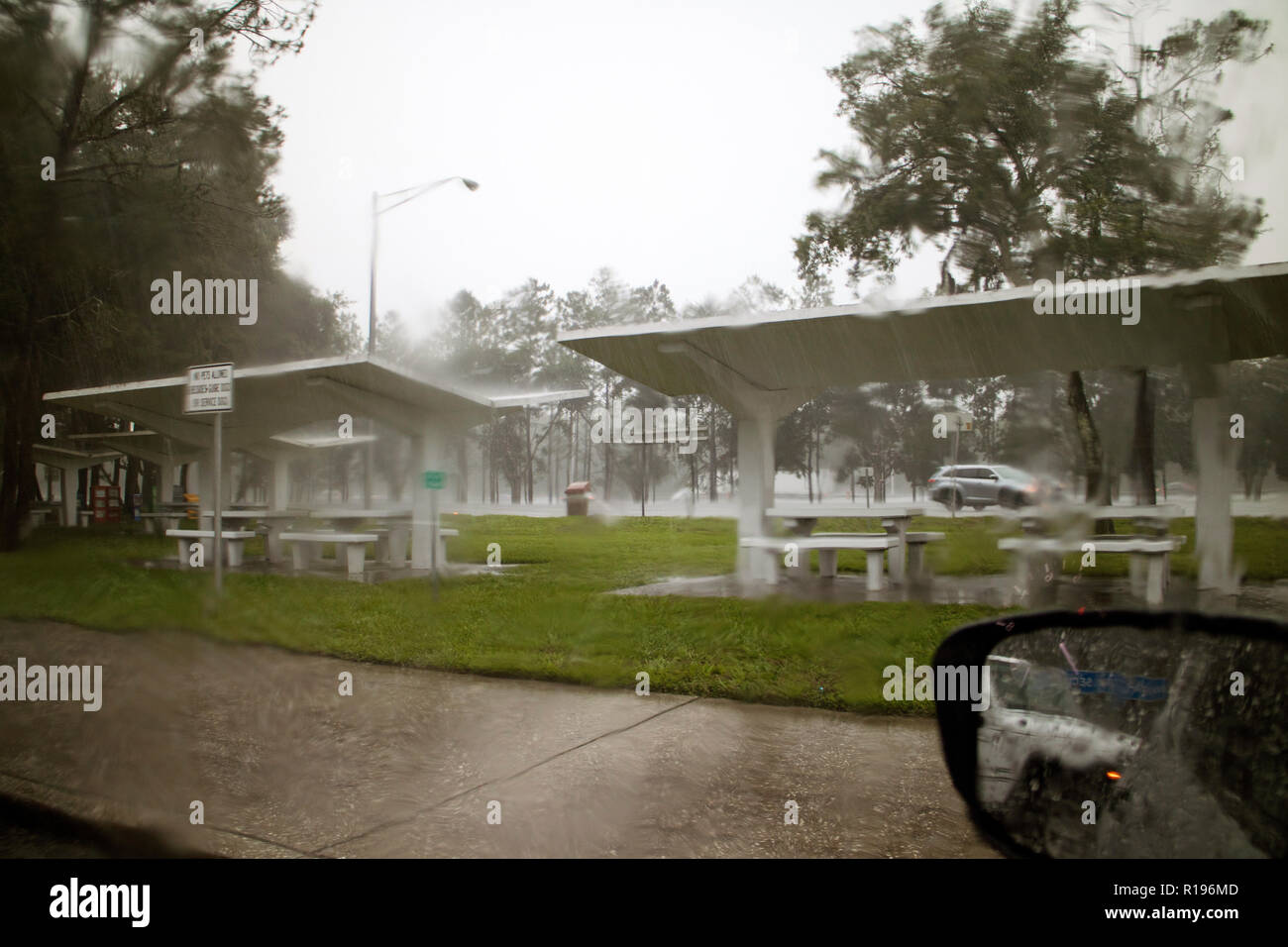 Heavy downpour of rain seen from car interior on an American reststop in Florida. Stock Photo