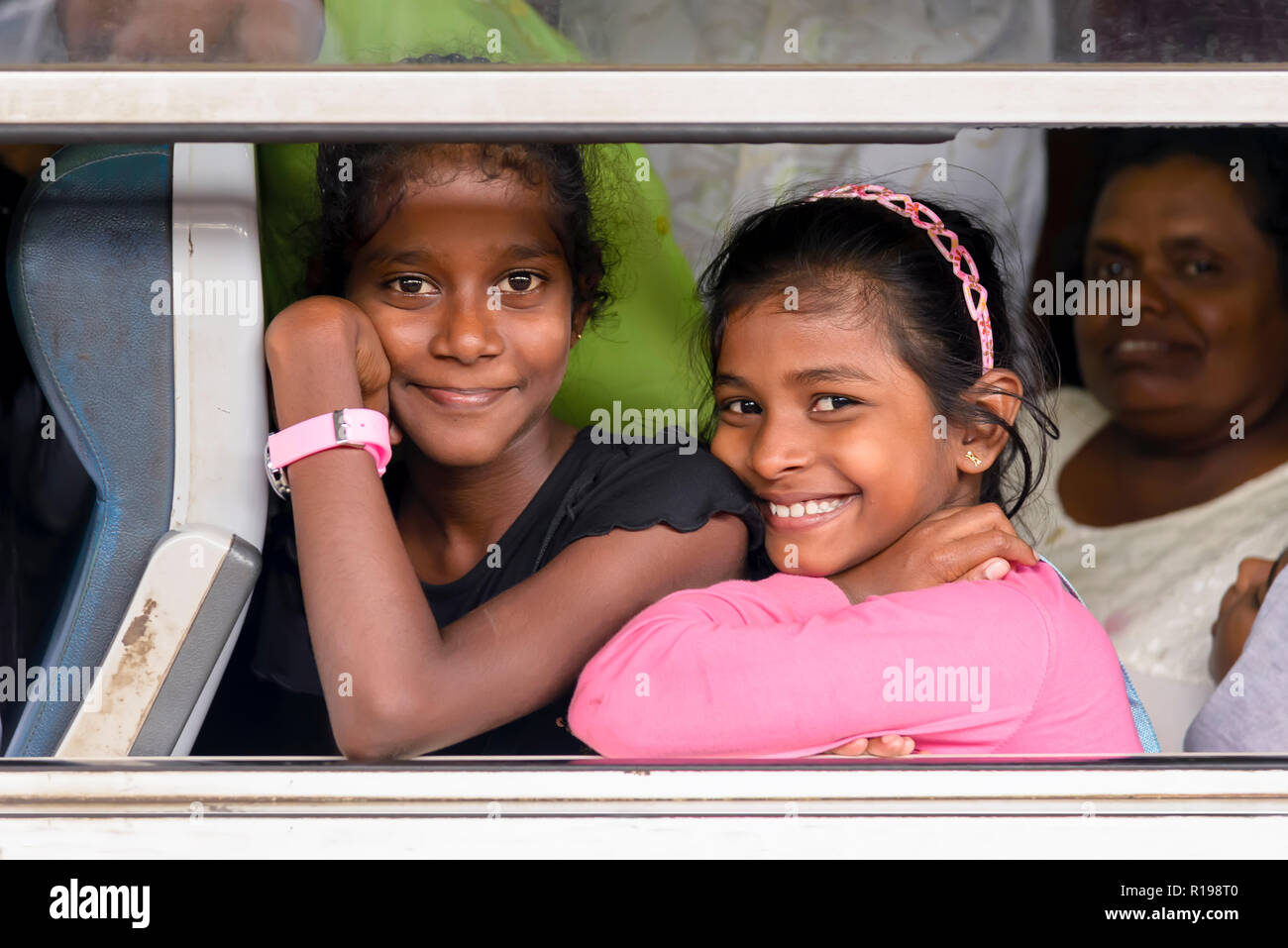 Kandy, Sri Lanka - August 19, 2017: Two smiling girls looking through window train at the Kandy's train station Stock Photo