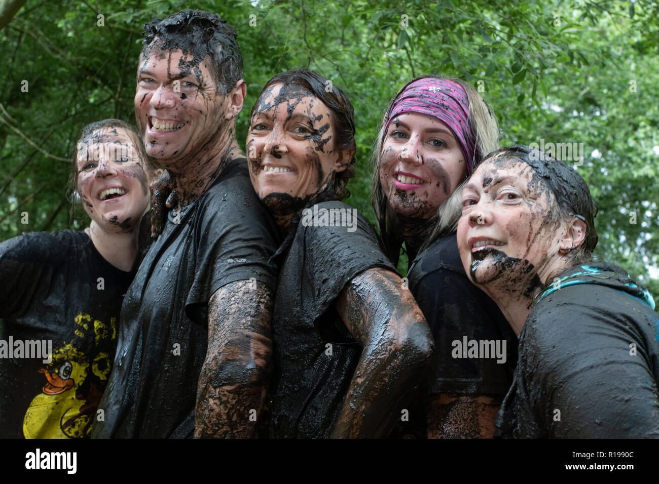 Mud runners posing hands on hips Stock Photo