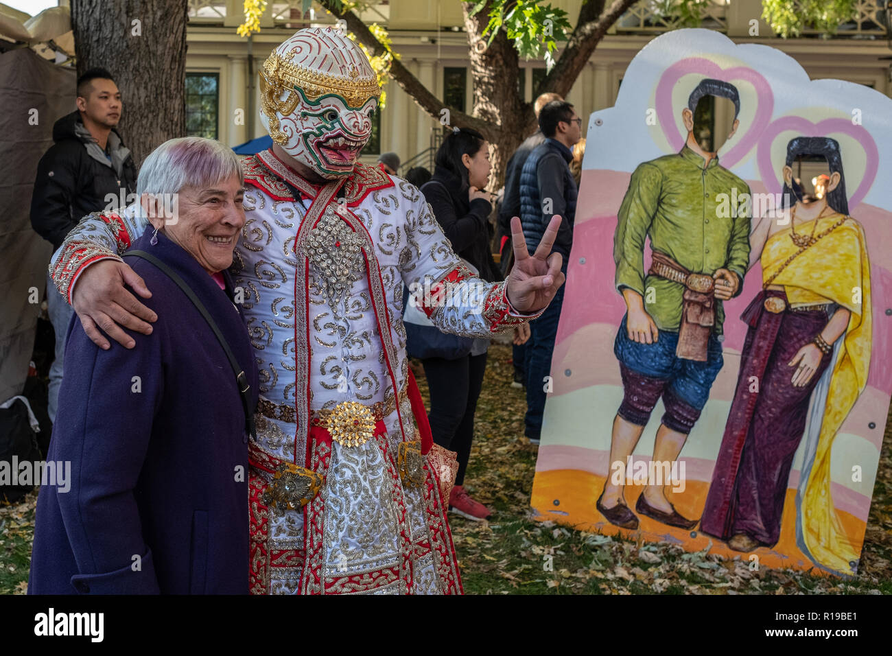 A woman having her photograph taken with a performer at the Thai Festival in Harvard Square Stock Photo