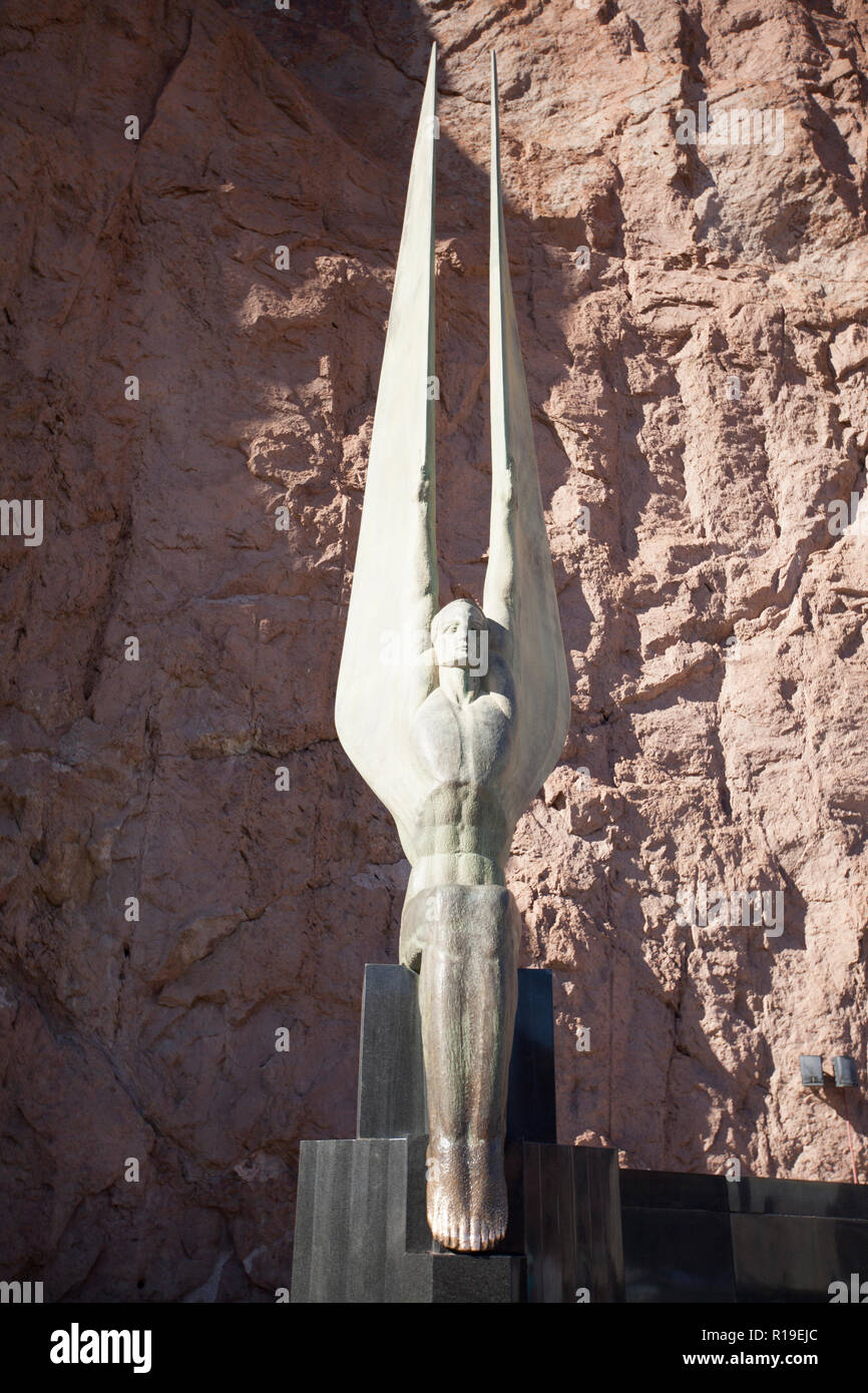 Two soaring figures flank a 142-foot flagpole at the Hoover Dam Visitors Center. The figures are ripped with muscles, raising their arms to extended w Stock Photo
