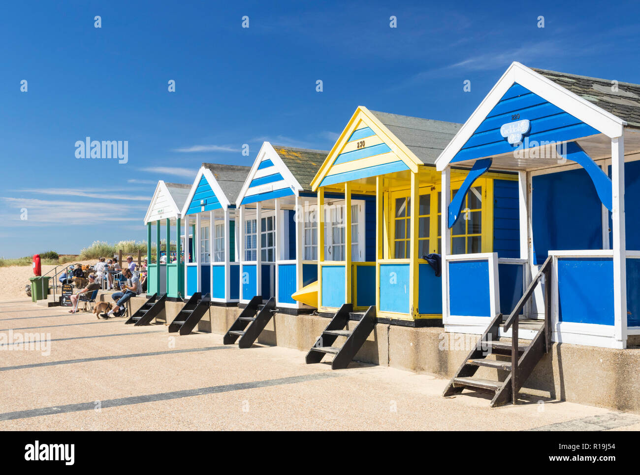 Southwold beach huts brightly painted beach huts holidaymakers at