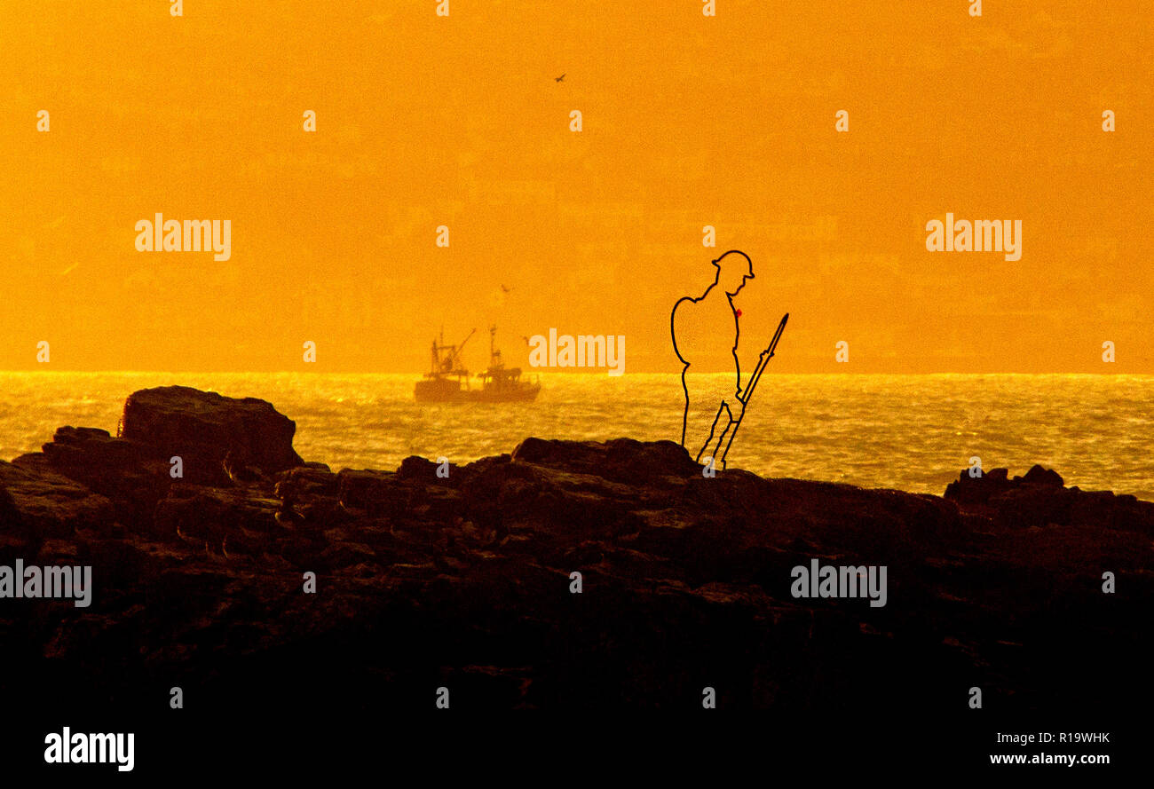 Marazion, Cornwall, UK. 10th Nov, 2018. A silhouette Tommy figure on Chapel Rock, in front of St Michael's Mount in Marazion, Cornwall, as part of There but not There project to commemorate those who gave their lives in WWI. Credit: Mike Newman/Alamy Live News Stock Photo