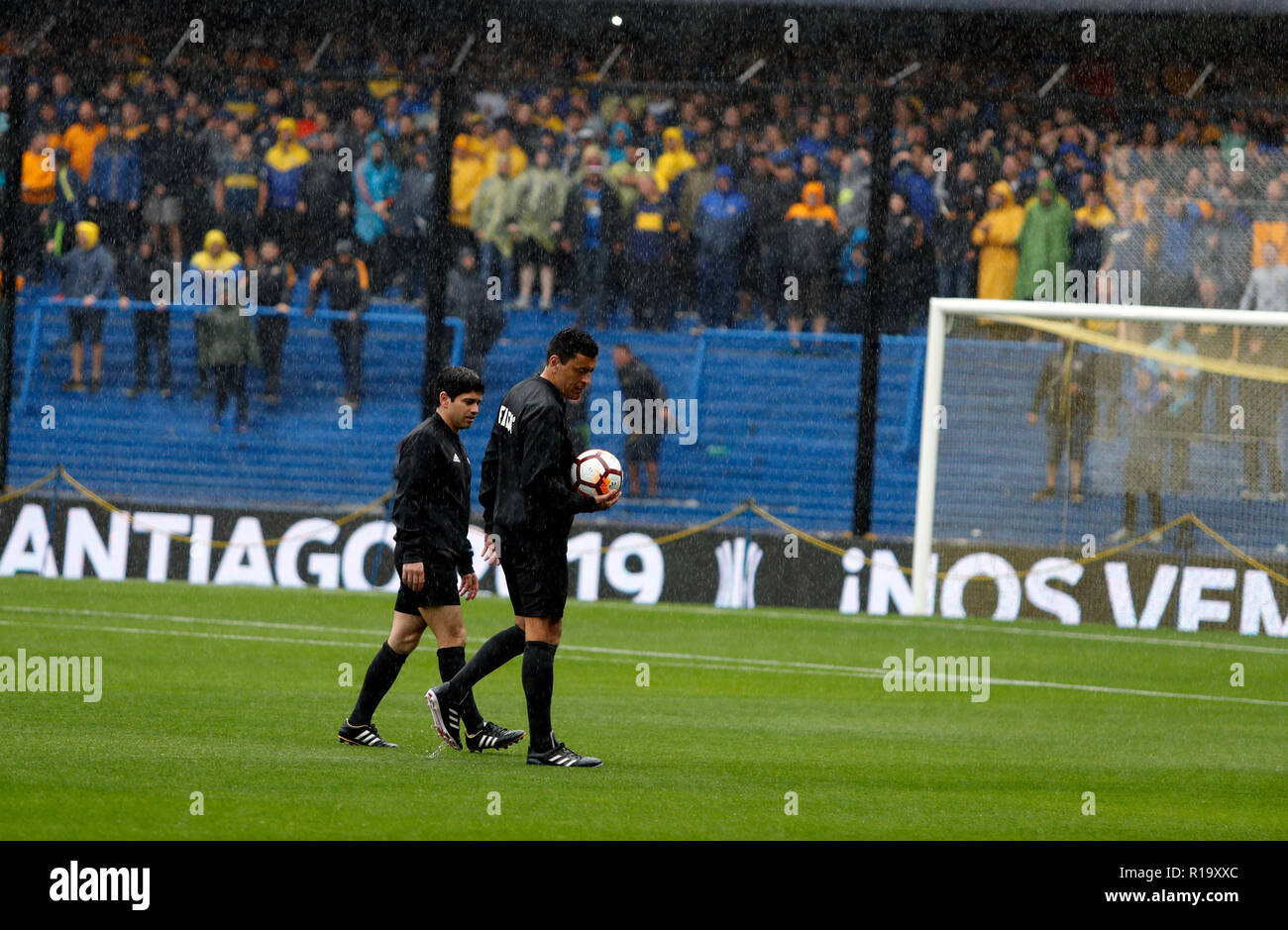 Buenos Aires, Argentina. 10th Nov, 2018. Chilean referee Roberto Tobar (r) crosses the pitch at Boca Juniors La Bombonera stadium. The first leg of the Copa Libertadores final between Boca Juniors and River Plate has been postponed due to pouring rain. The first big Argentine final of the South American Champions League will take place on Sunday 11.11.2018. Credit: Ortiz Gustavo/dpa/Alamy Live News Stock Photo