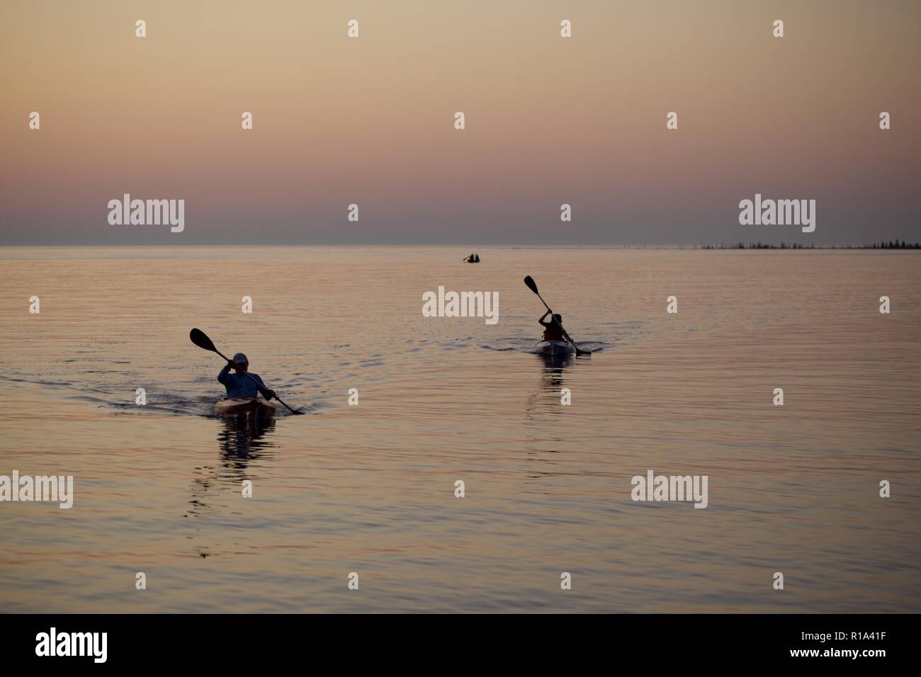 People on lake in canoe during a summer sunset, Ontario Canada Stock Photo