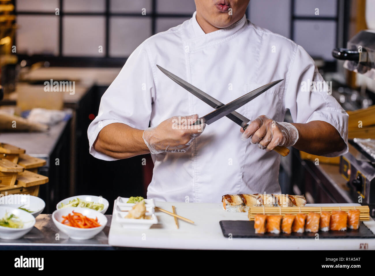 man in white uniform with crossed knives Stock Photo