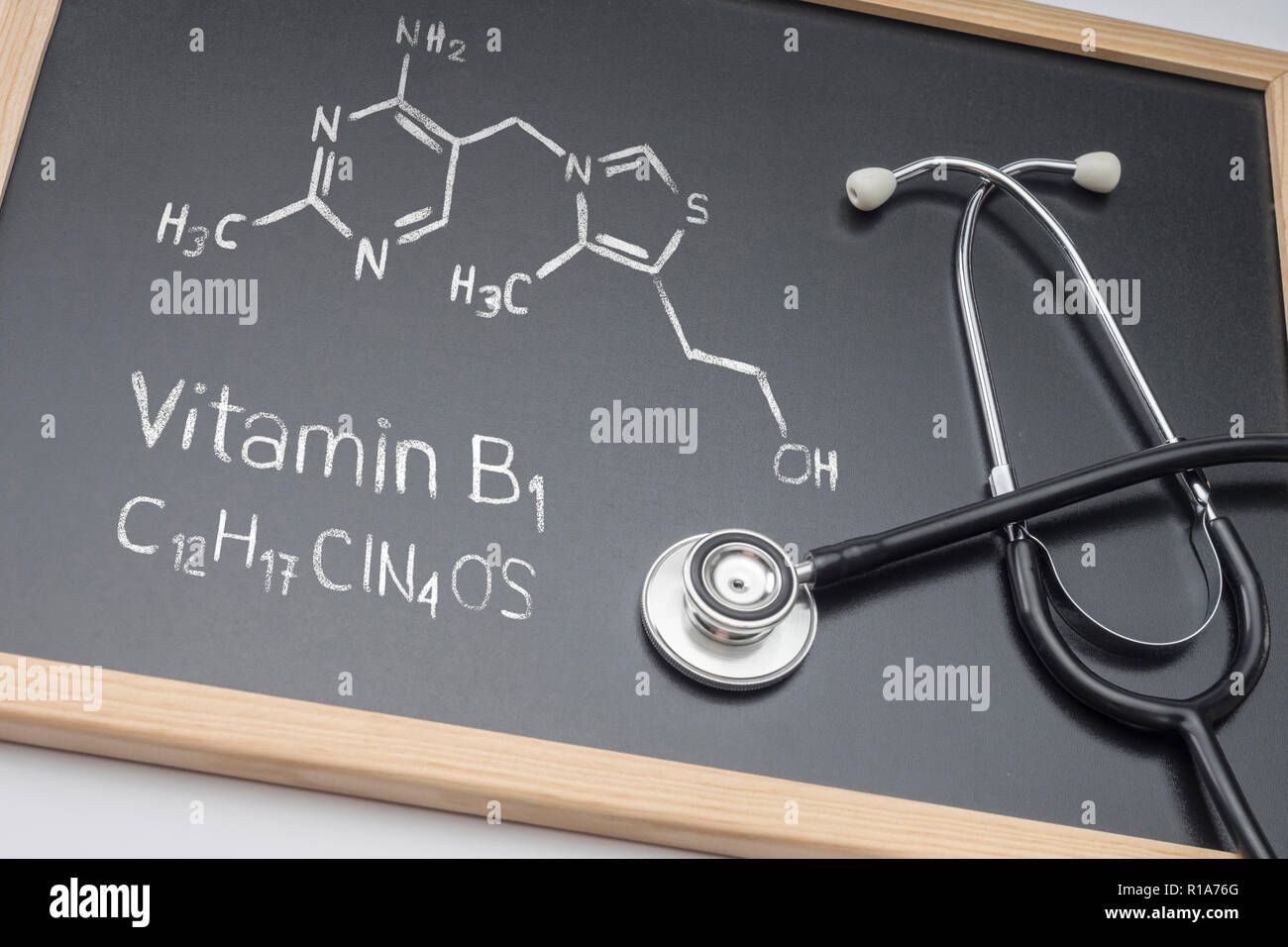 Chemical formula of vitamin B1 drawn on a whiteboard together with a stethoscope, conceptual image Stock Photo
