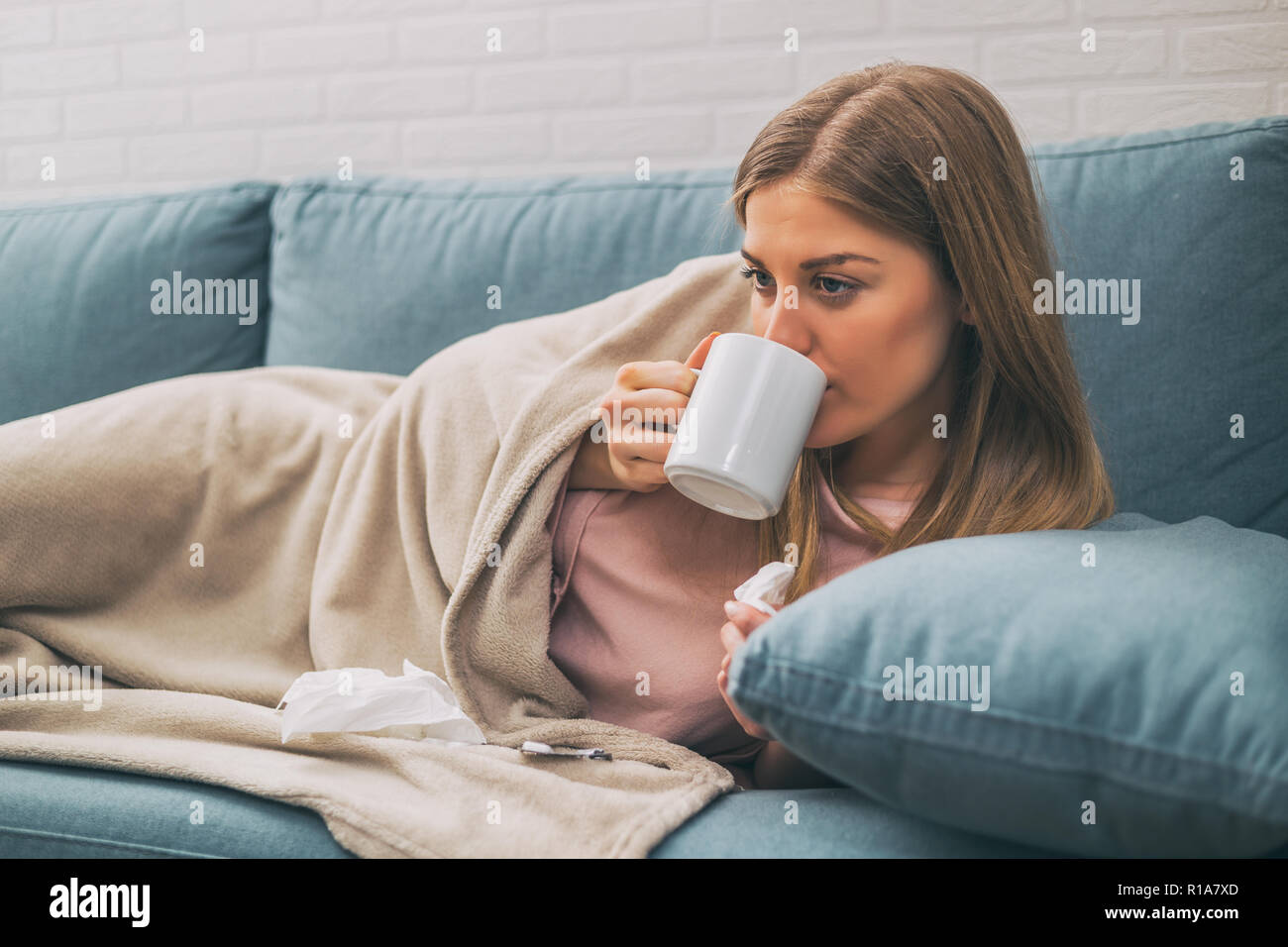 Exhausted woman having fever and she is drinking a tea Stock Photo Alamy