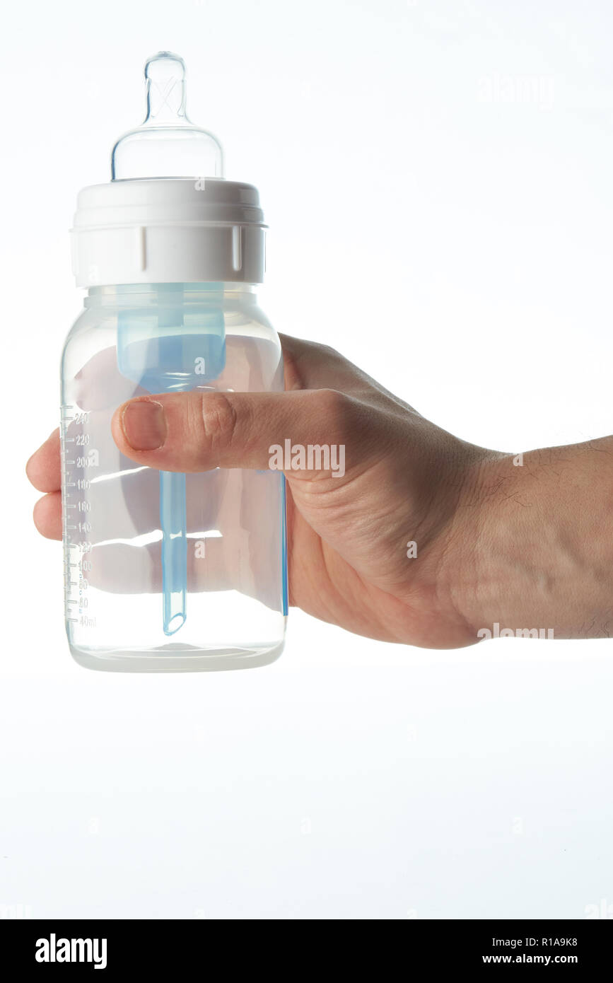 Milk feeding baby bottle in hand isolated on white background Stock Photo