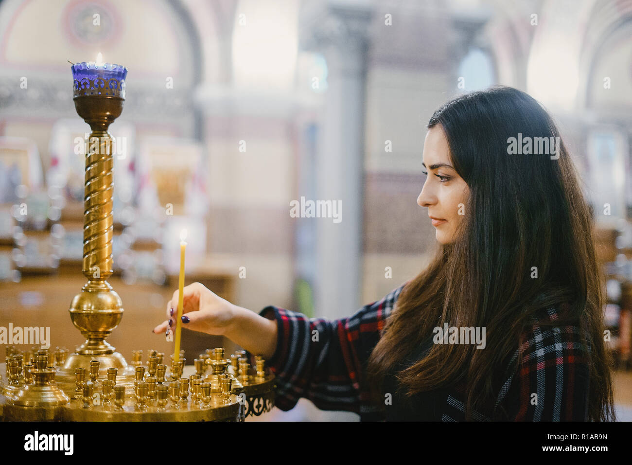 girl lighting a candle in the church Stock Photo