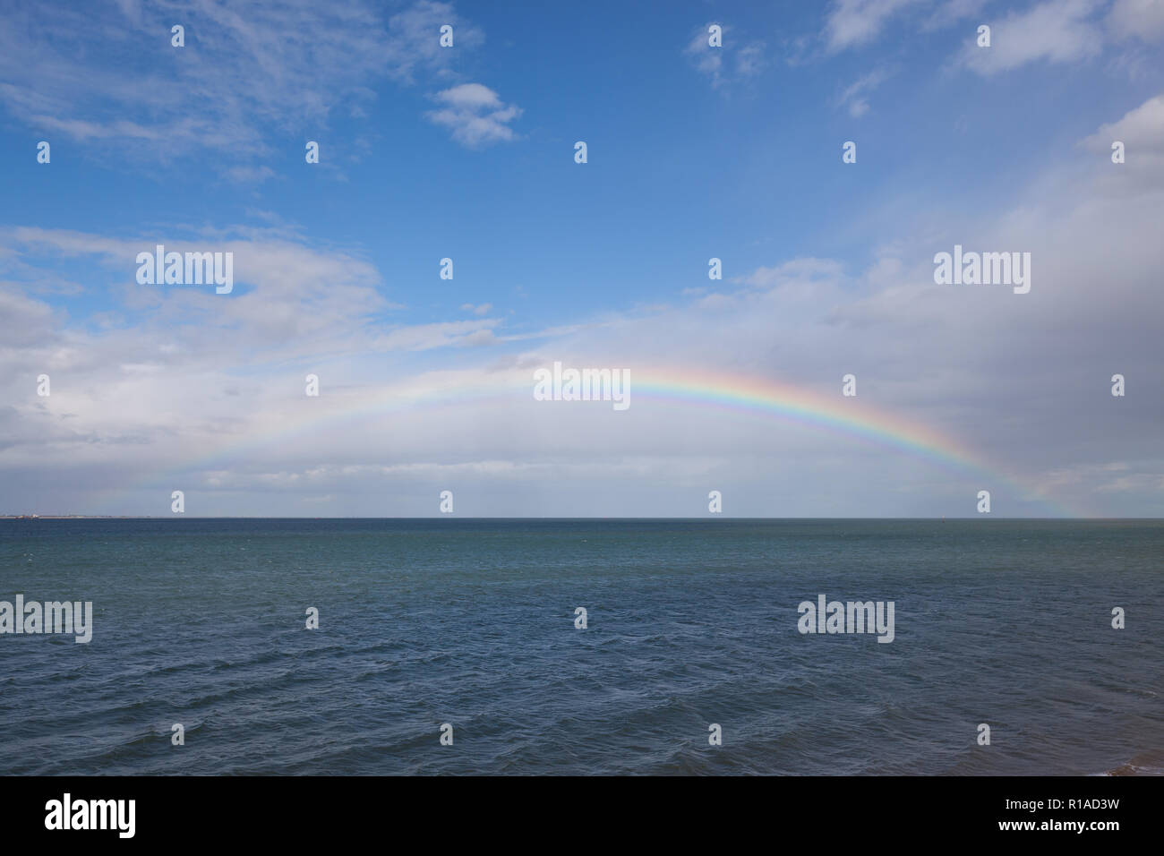 Rainbow seen out at sea Stock Photo - Alamy