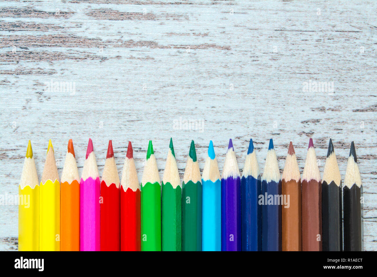 Colored multicolored pencils close up macro down on a vintage wooden