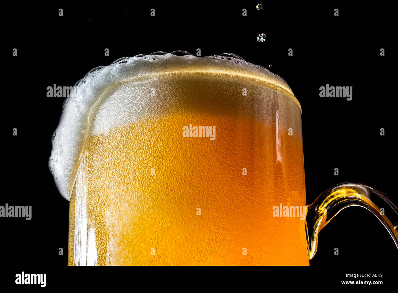Close up of an overflowing glass of beer hires stock photography and