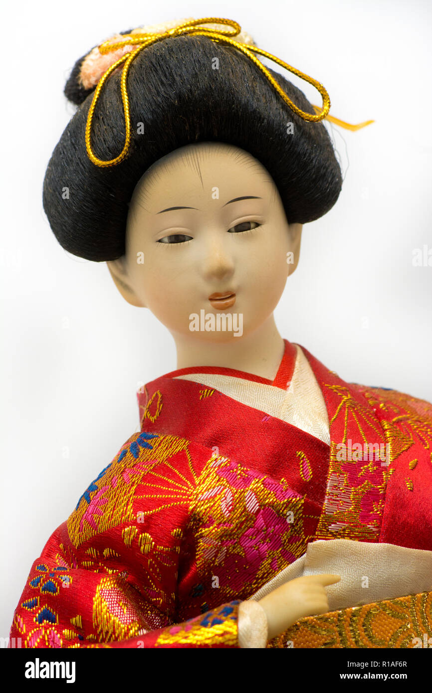 Japanese Geisha doll in red kimono isolated on white background Stock Photo