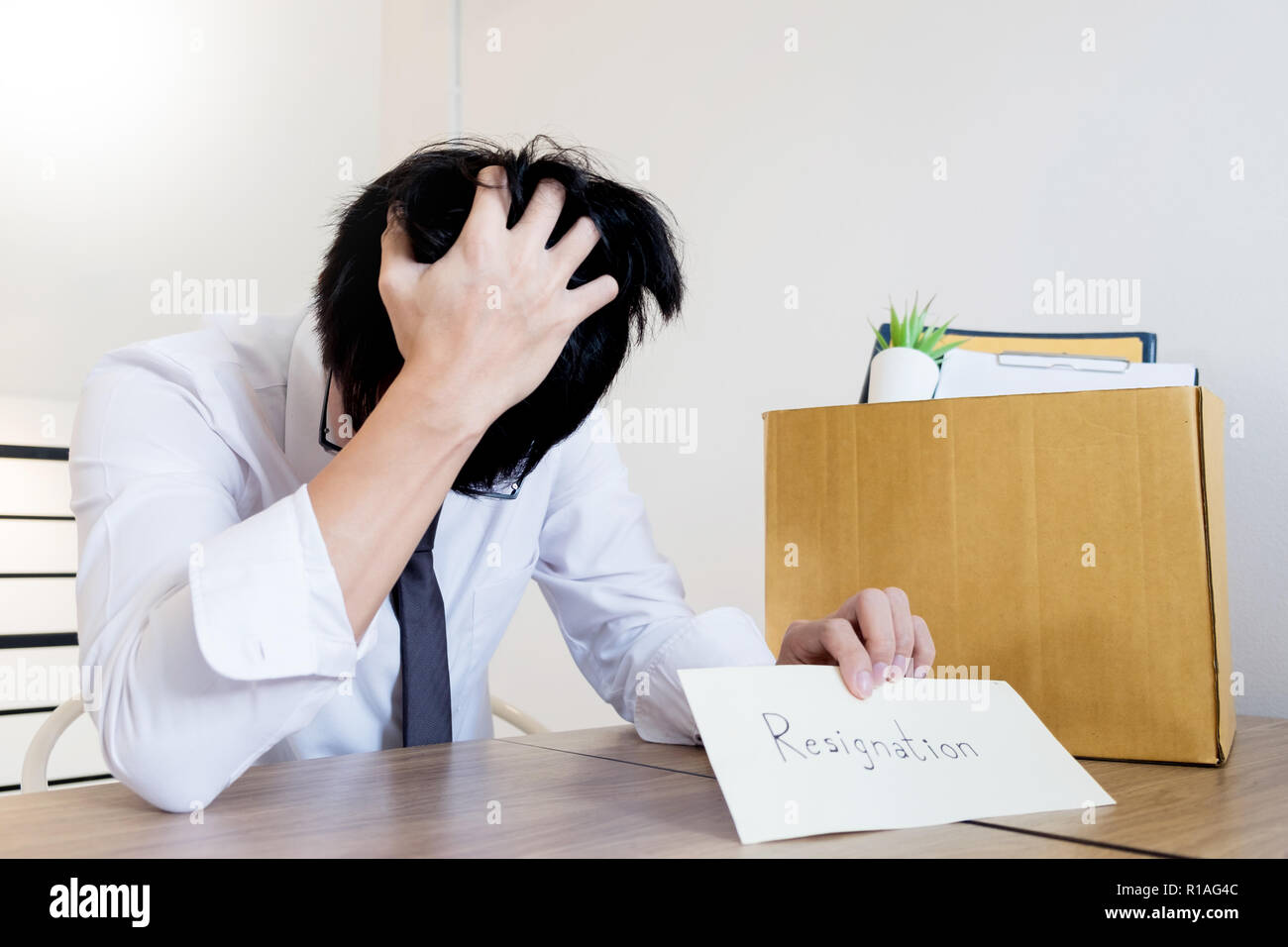 Putting Paper Businessmen are holding resignation document and packing personal ...