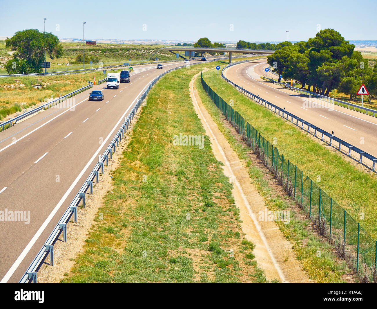 Vehicles crossing a european highway at a sunny day. Stock Photo