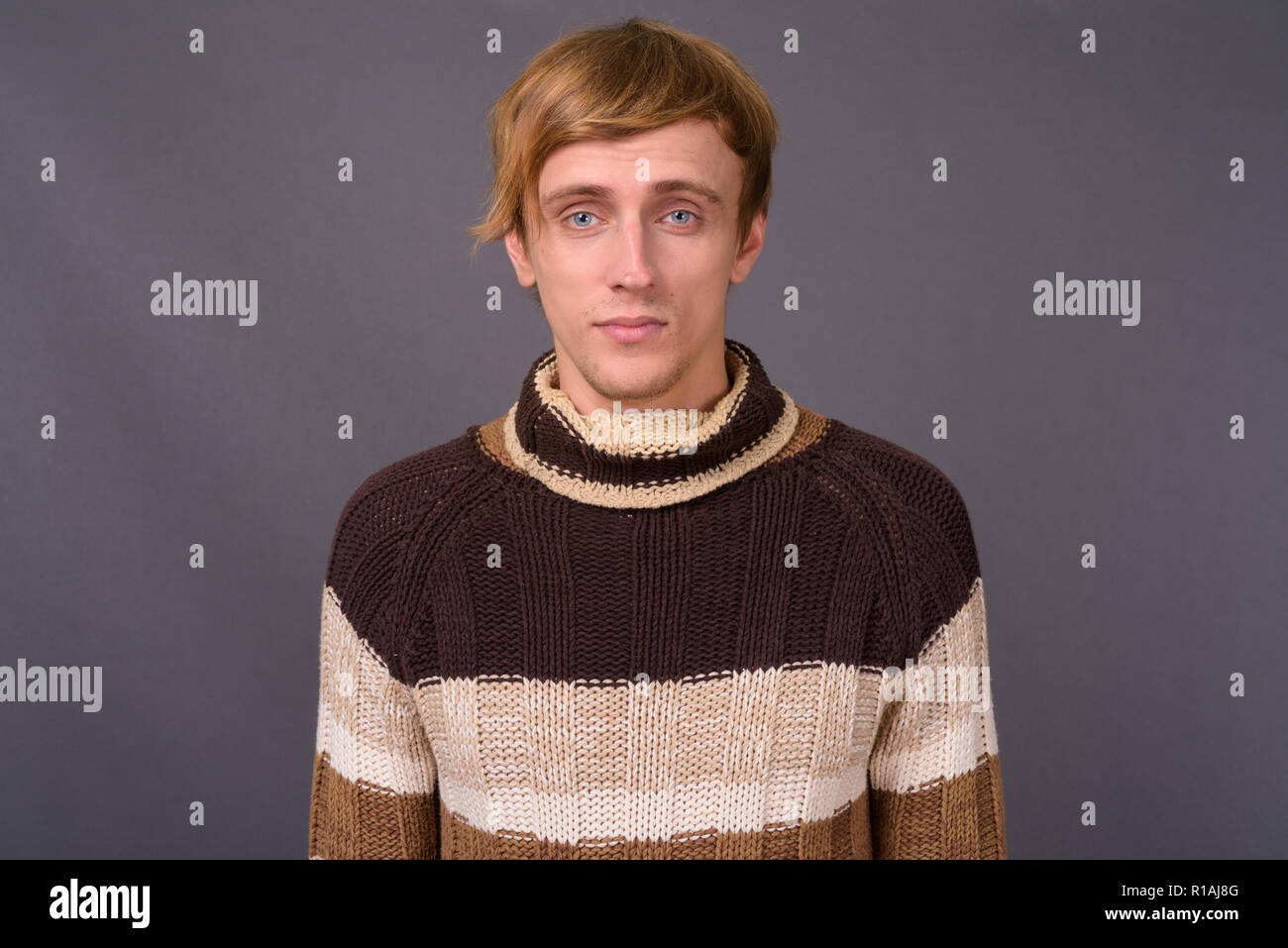 Young handsome man with blond hair against gray background Stock Photo