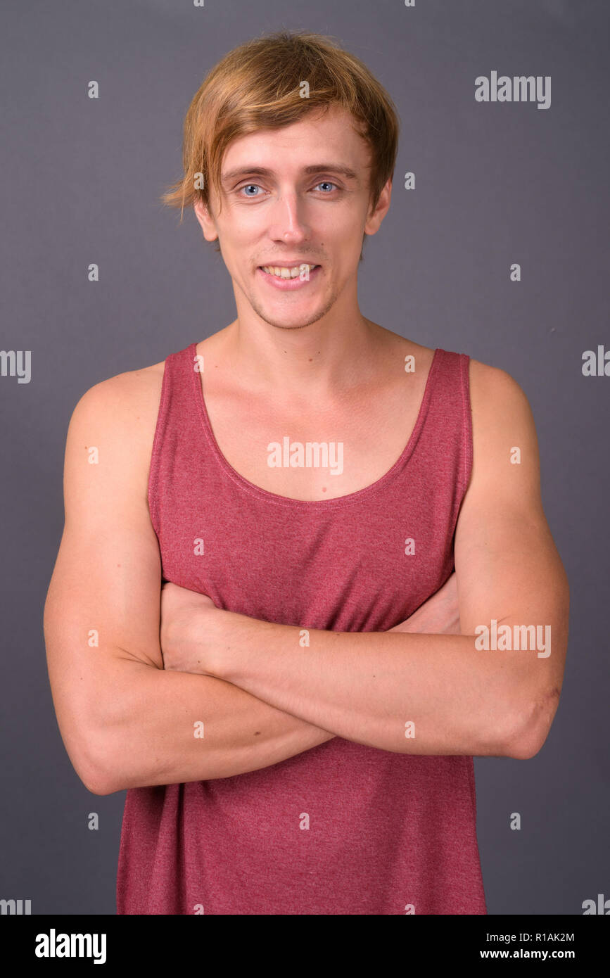 Young handsome man ready for gym against gray background Stock Photo