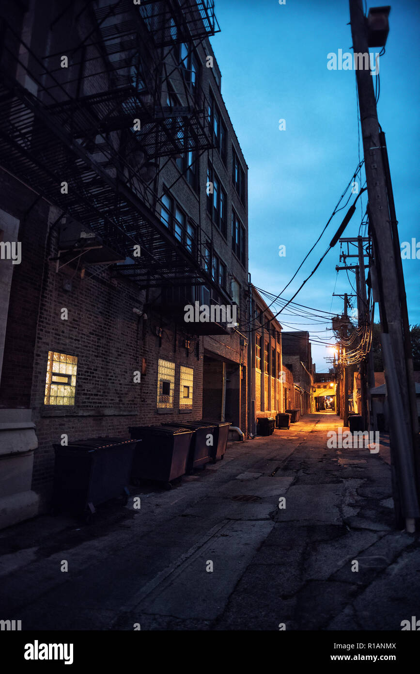 Dark And Scary Downtown Urban City Street Alley With An Eerie Vintage Industrial Warehouse Factory And A Dumpsters At Night Stock Photo Alamy