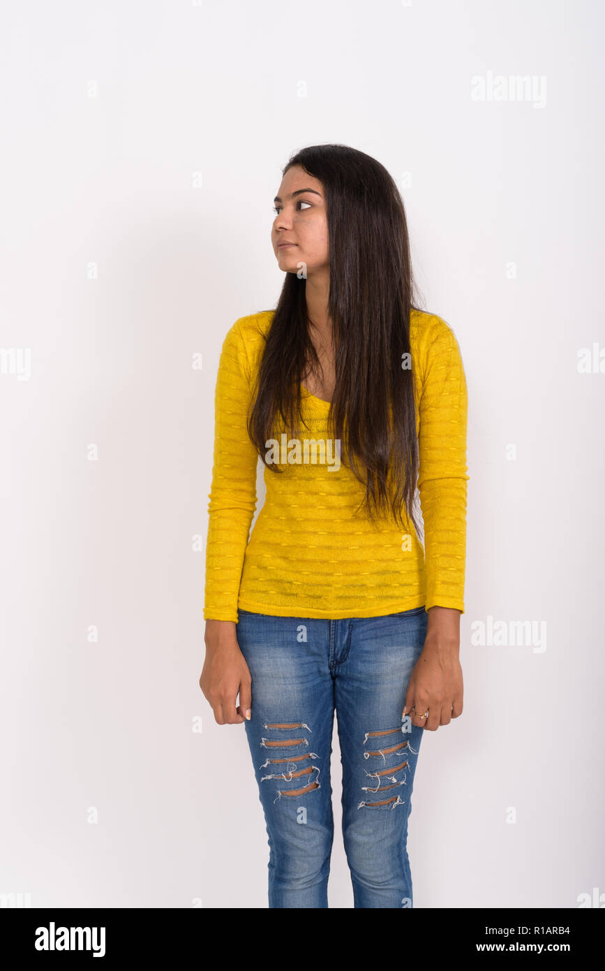 Profile view of young Indian woman standing while thinking with  Stock Photo