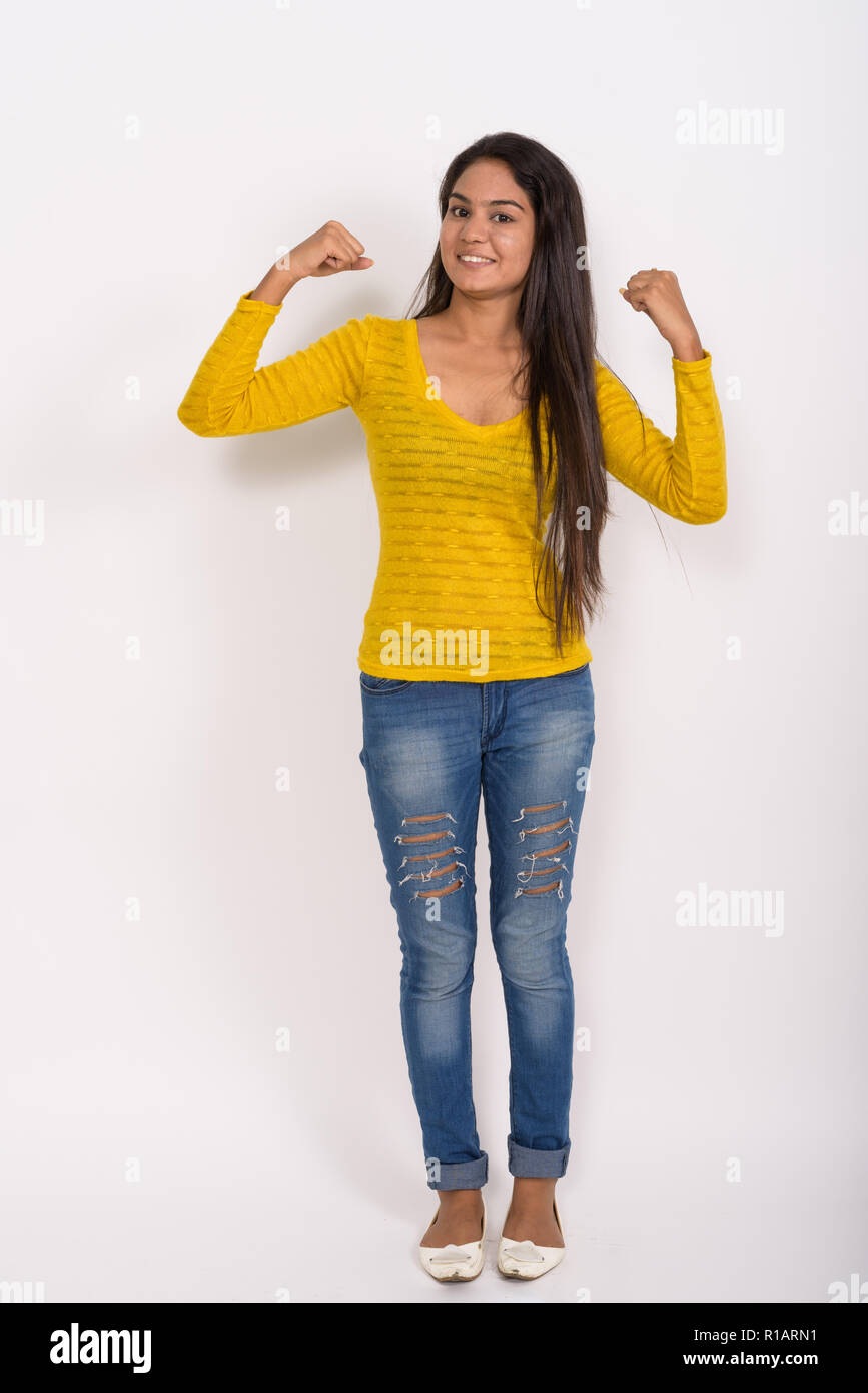 Full body shot of young happy Indian woman smiling and standing  Stock Photo