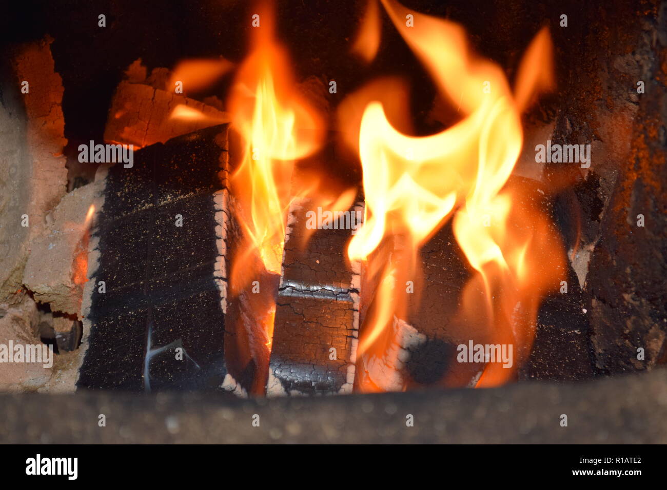 Close up of Brown Coal Briquettes on fire with red yellow flames inside