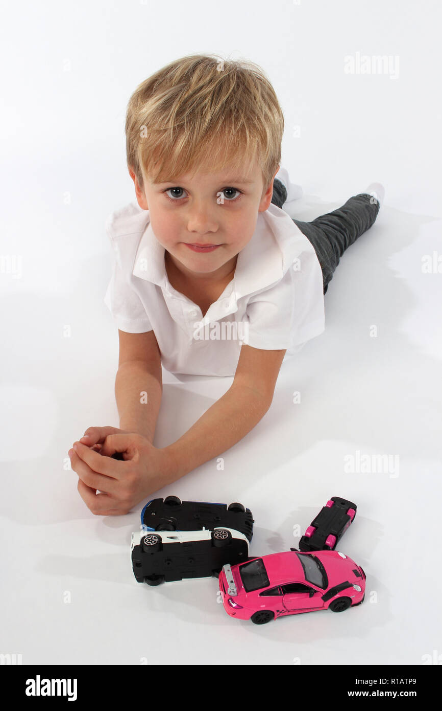 Cute little boy playing with toy cars Stock Photo - Alamy