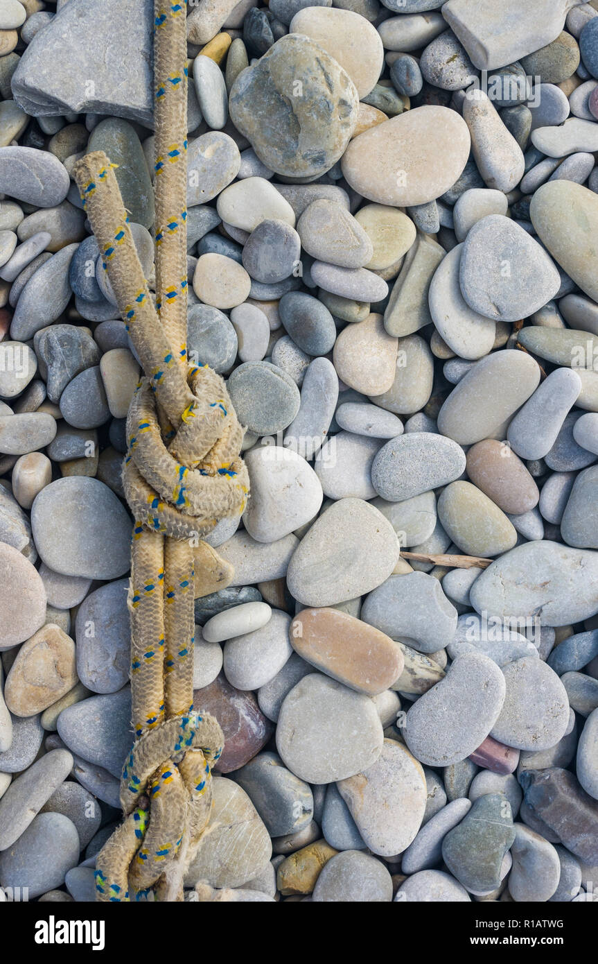 High Rope Pebble Bridge old worn battered marine rope on the pebble beach on a Sunny summer day ...