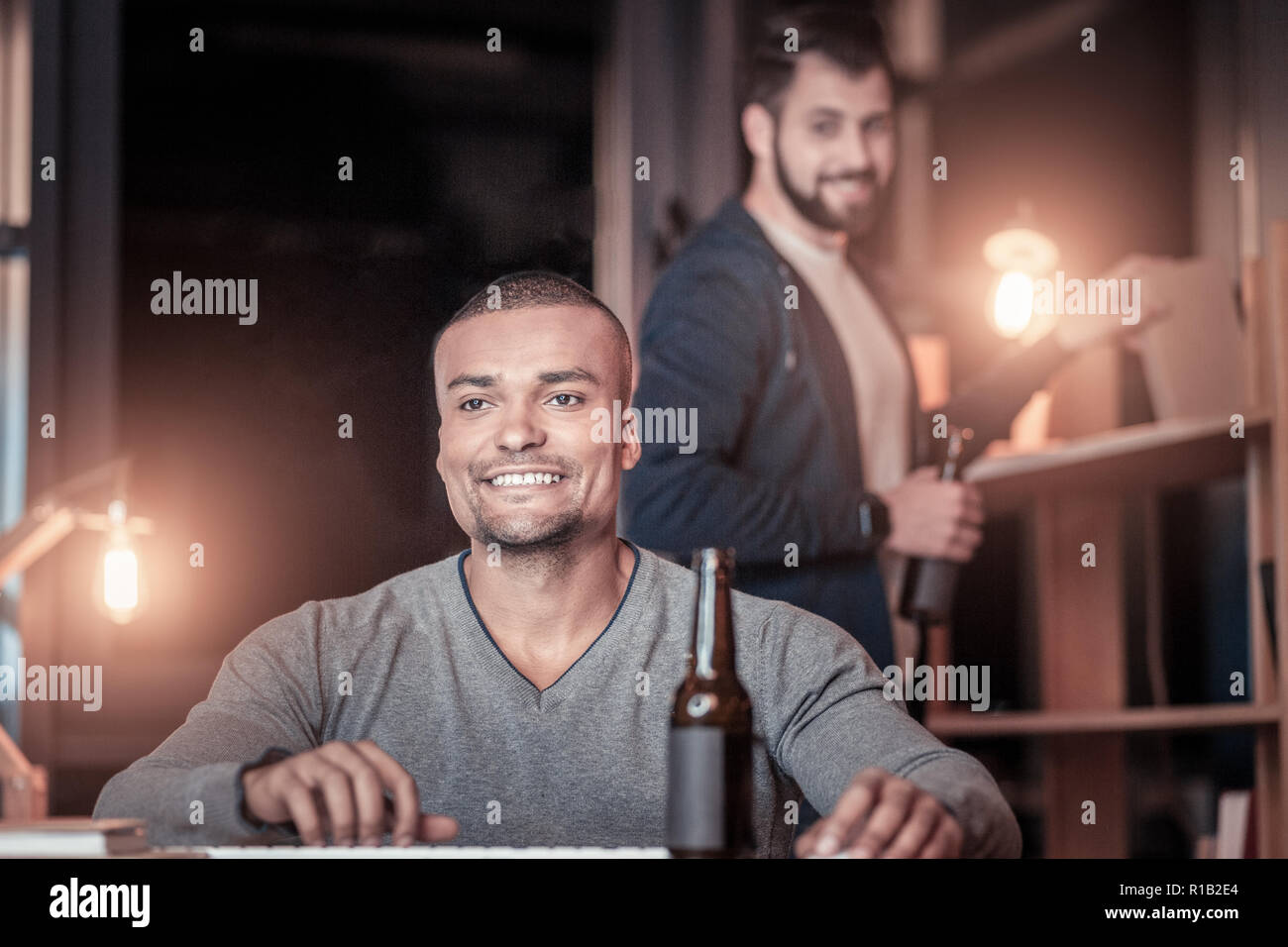 Positive delighted young man working in office Stock Photo