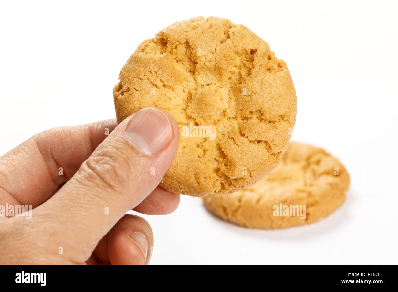 Hand holding a Cookie on white background , close up. Stock Photo