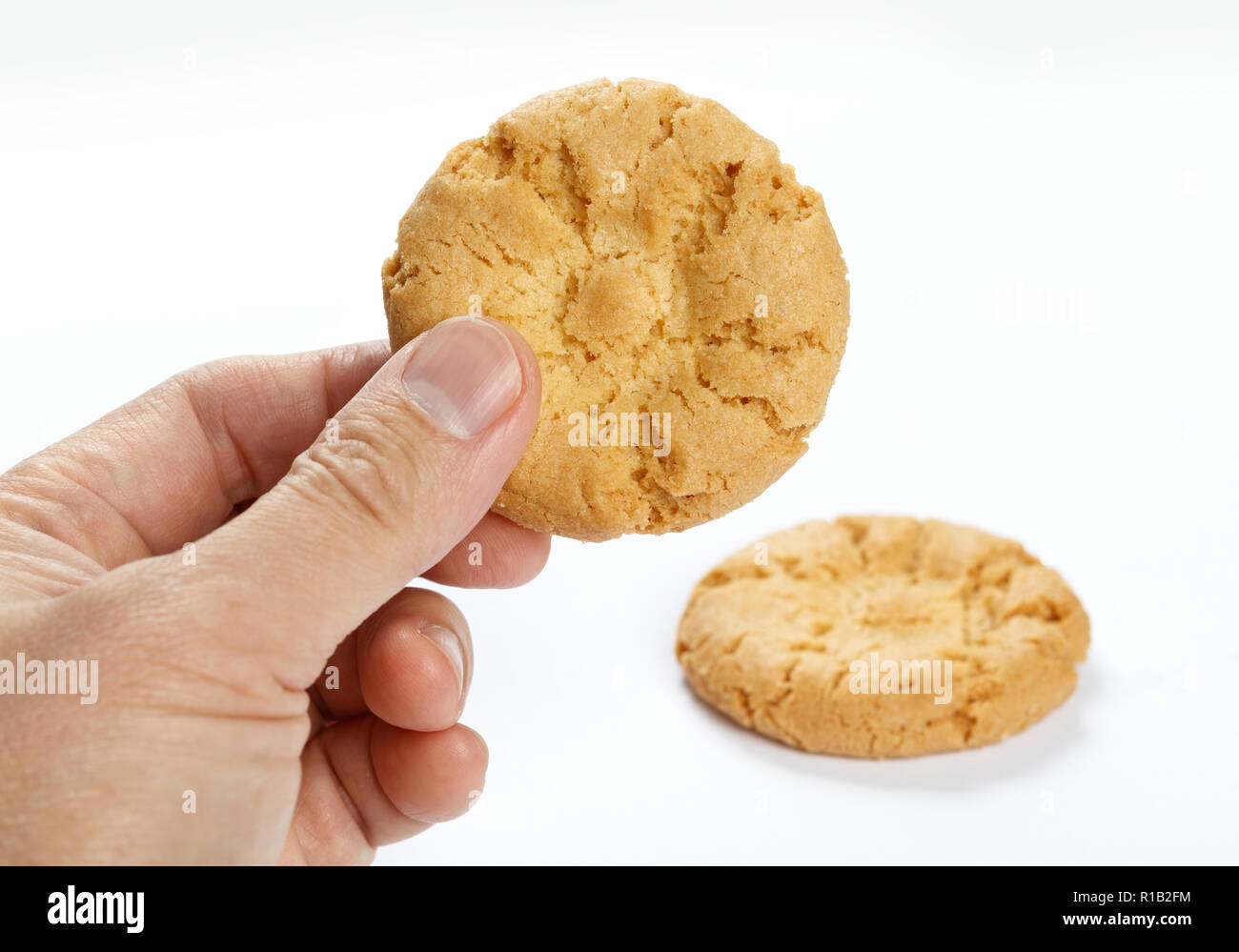 Hand holding a Cookie on white background , close up. Stock Photo