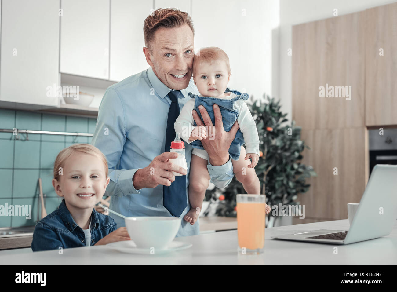 Satisfied handsome father smiling and spending time with children. Stock Photo