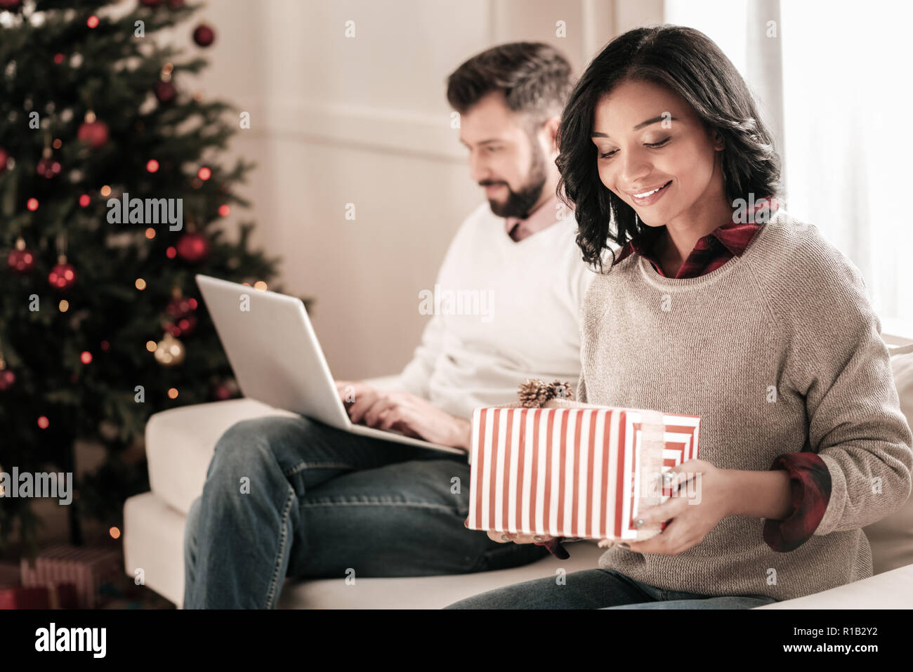 Dreamy girl holding gift box in both hands Stock Photo