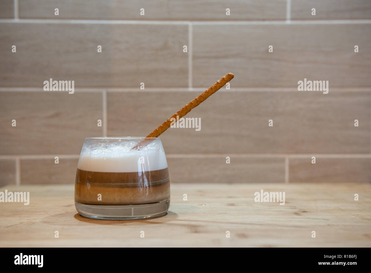 multilayer coffee or cappuccino in a glass cup with bread straw Stock Photo