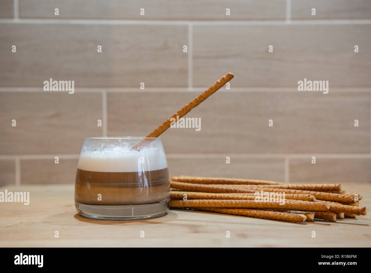 multilayer coffee or cappuccino in a glass cup with bread straw Stock Photo
