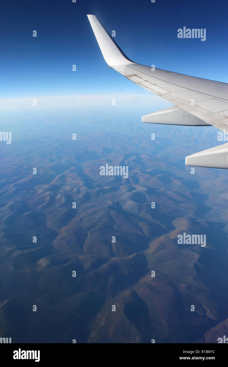 Mountain landscape under the wing of an airplane Stock Photo