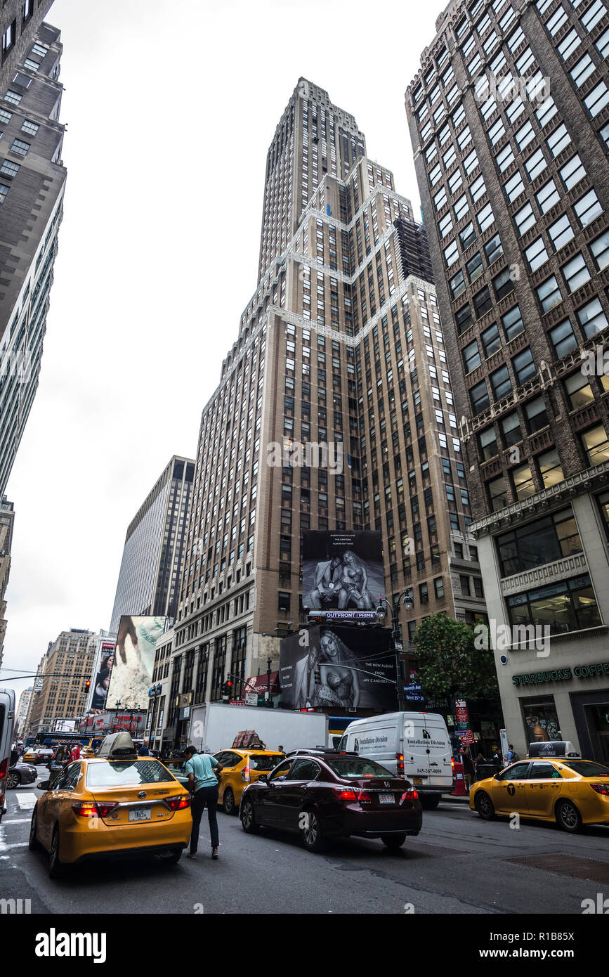 New York City, USA - July 25, 2018: Seventh Avenue and 35th Street with huge advertising screens of Jay-Z and Beyonce and people around in Manhattan i Stock Photo