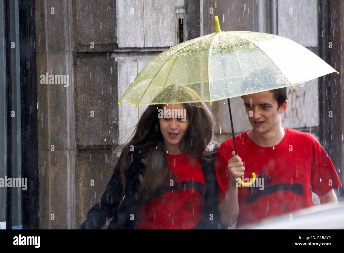 Happy couple under umbrella in the rain Stock Photo - Alamy