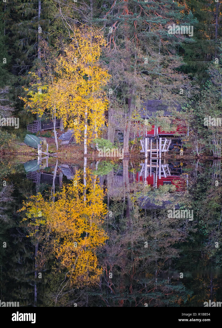 Idyllic lake view with cozy cottage and fall colors reflection at autumn day in Finland Stock Photo
