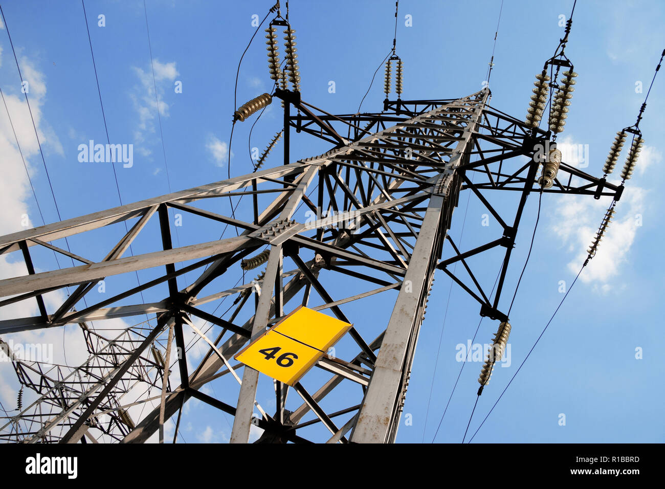 A high voltage power pylons against blue sky and clouds Stock Photo - Alamy