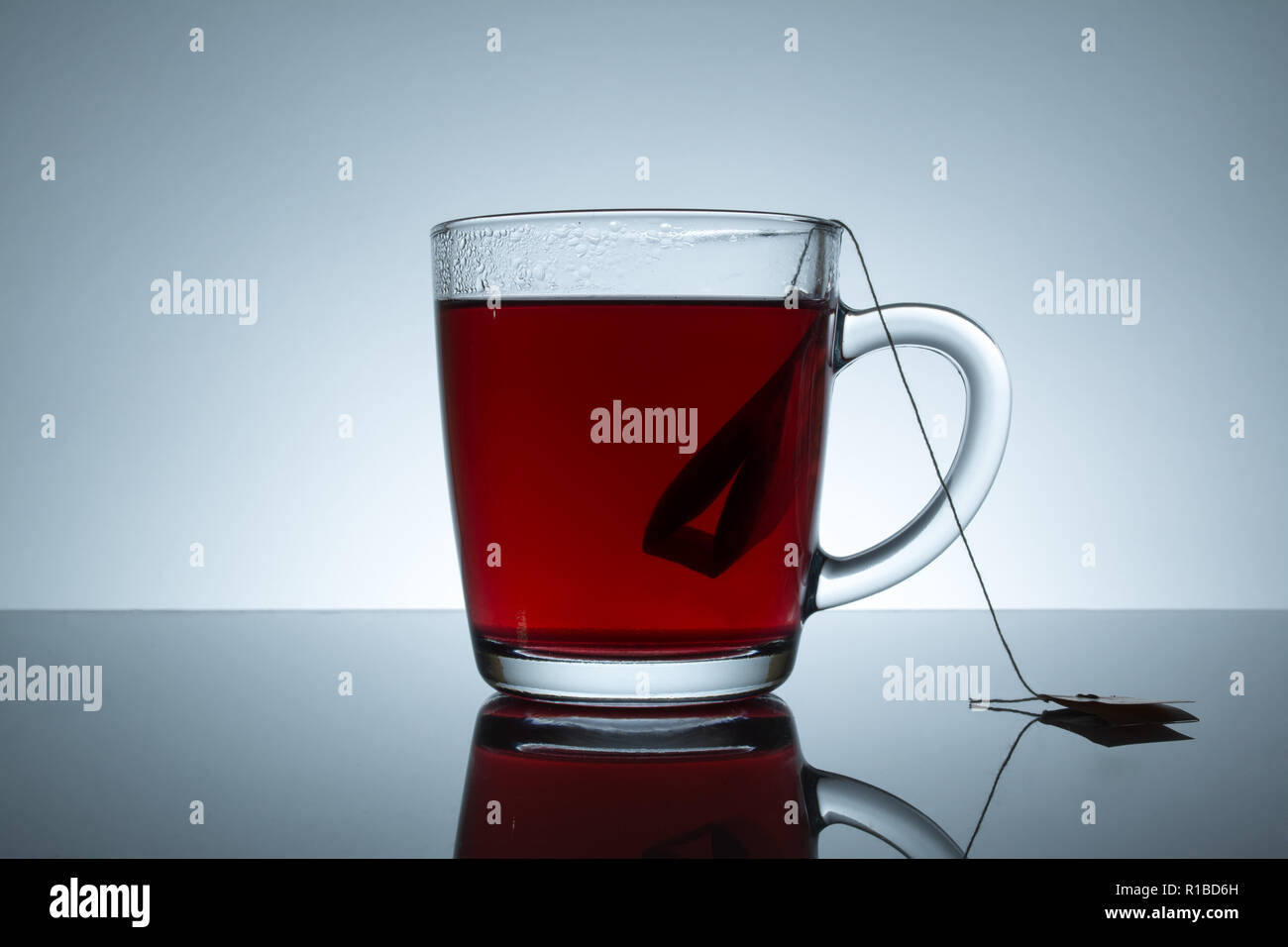 tea bag in a transparent mug with reflection on a grey background Stock Photo