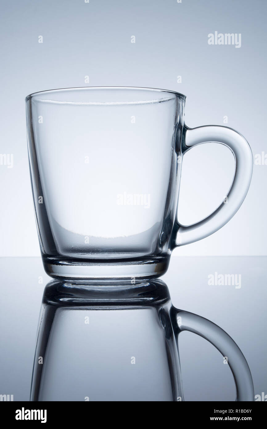 transparent mug with reflection on a grey background Stock Photo